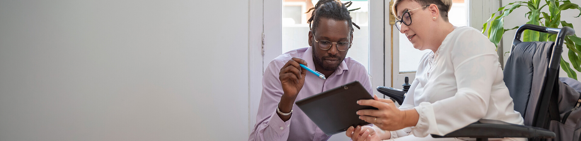 Two people looking at a tablet device